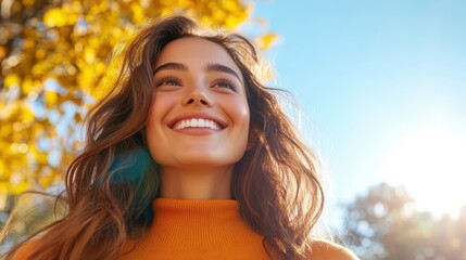 Fototapeta premium A woman with a radiant smile and long flowing hair is surrounded by golden autumn leaves, basking in sunlight, symbolizing joy, warmth, and harmony with nature.