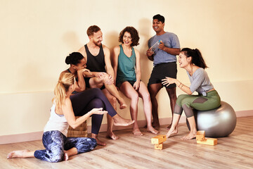 Fototapeta premium People, talking and happy in yoga class for teamwork, discussion and bonding together with diversity. Group, smile and support in studio for spiritual conversation, exercise and fitness with friends