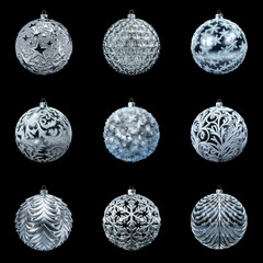 A set of silver Christmas tree balls standing out against a black background. Festive Christmas decorations with beautiful patterns.