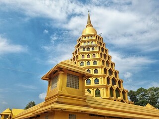 Golden Pagoda under Blue Sky: A majestic golden pagoda, intricate in design and gleaming under a...