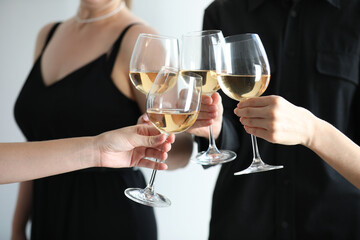 People clinking glasses of wine indoors, closeup