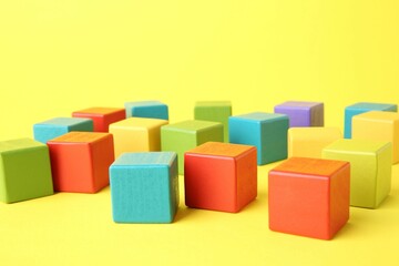 Obraz premium Many wooden colorful cubes on yellow background