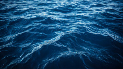 Obraz premium Aerial View of Surface Waves on a Tranquil Blue Sea, Capturing the Fluid Motion and Patterns of Water