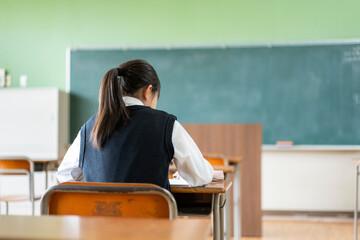 教室で勉強する女子中学生の後ろ姿