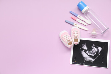 Composition with baby shoes, sonogram image, pregnancy tests and bottle on purple background