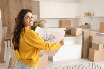 Beautiful woman with house plan in kitchen on moving day