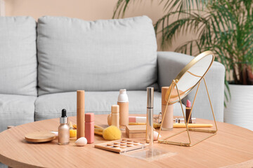 Decorative cosmetics, makeup accessories and mirror on wooden table in room