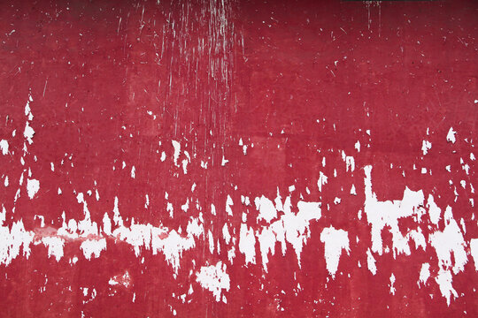 Red wall with peeling and stained paint