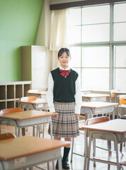 教室の中で立っている日本人の女子中学生のポートレート