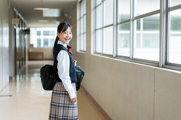 学校の廊下で振り返る日本人の女子中学生のポートレート
