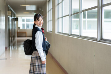 学校の廊下で振り返る日本人の女子中学生のポートレート
