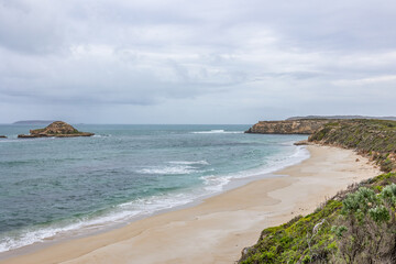 The coastline at Innes National Park with Chinamans Hat Island just offshore under an overcast sky...