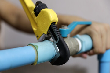 Plumber using a wrench to repair a water pipe. Concept of water pump maintenance fix water plumbing...