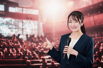 大勢の聴衆の前で話す女性