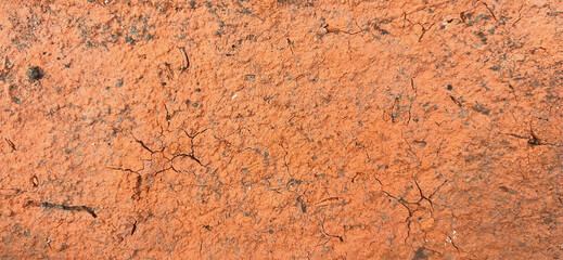 Close-up view of the textured surface of a cracked orange brick. Premium classic wall background photo for banner background or wallpaper.