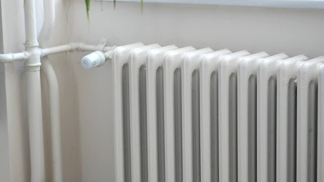 White radiator on grey white wall. apartment heating installation system, 