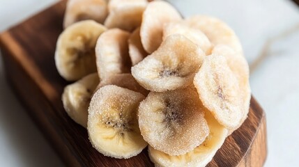 Fototapeta premium Dried Banana Slices on a Wooden Board