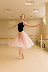 Ballet dancer performing a pirouette en pointe, gracefully extending arms in a bright studio