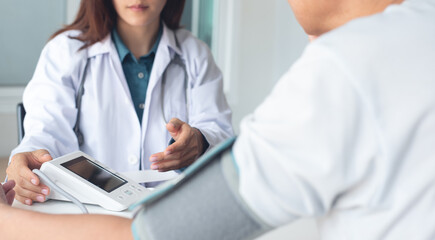 Close up, doctor examining a male patient's heart rate and measuring blood pressure with a blood...