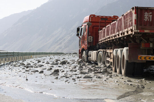 Kizilsu Kyrgyz Autonomous Prefecture, Xinjiang, China - Aug 13, 2024: A truck caught in a mudflow triggered by snowmelt during summer on a mountain highway in Western Xinjiang, China.