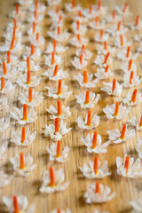 Parijat flowers, also known as Nyctanthes arbor-tristis or Night-flowering Jasmine, arranged in a straight row on a wooden floor.