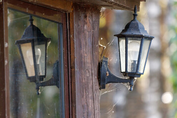 A black lamp is lit up and is reflected in a window