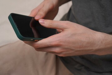 hands of young man working on smartphone close-up