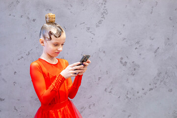 girl with a beautiful hairstyle in a ballroom sports dress takes a selfie on the phone after the...