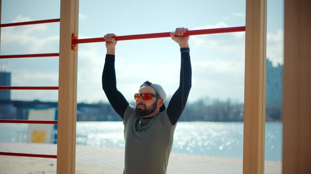 Outdoor fitness enthusiast performing pull-ups by the river