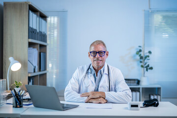 Confident doctor smiling while sitting at desk in office