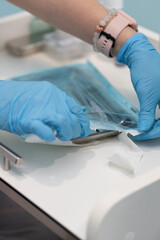 Dental professional preparing instruments for an upcoming patient appointment in a modern clinic setting during daylight hours