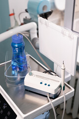 Dental clinic equipment setup featuring hygiene tools, treatment instruments, and water bottle in a modern facility
