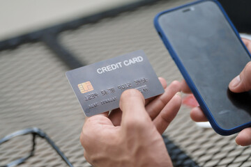 A businessman sits at a table, using his credit card to make an online payment on his laptop. He enjoys a lifestyle of frequent travel, shopping, and smart financial habits for wellness