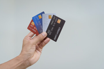 A close-up of a man’s hand holding a bank credit card against a white background, emphasizing secure online payment services and financial convenience for shopping and banking transactions