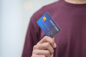 Close-up of a man's hand holding a bank credit card, highlighting online services for lending and access to credit,demonstrating financial convenience and flexibility for secure digital transactions