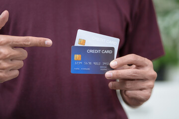 Close-up of a man's hand holding a bank credit card, highlighting online services for lending and...