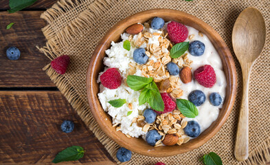 Cottage cheese for breakfast with granola, yogurt and fresh berries. Healthy breakfast. Top view