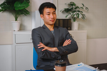 A businessman works late at his desk, focused on his laptop while talking online. He checks...