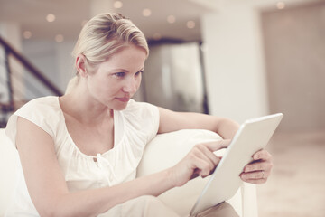 Tablet, sofa and woman scroll app, reading email and internet search for ebook in home. Lounge, relax and person with digital technology for online shopping, download and check social media profile