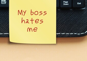 Note stick on keyboard with text written My boss hates me - feeling you are disliked by supervisor...