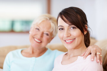 Happy, women and portrait of family, mother and adult daughter with smile in home with bonding. Generations, care and weekend on living room couch with hug, support and love in lounge with embrace