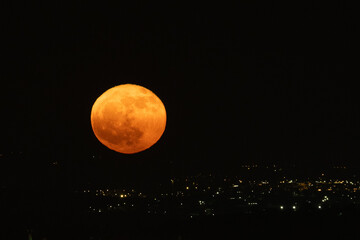Full red moon rises over a village