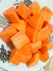 cut papaya fruit on a white plate