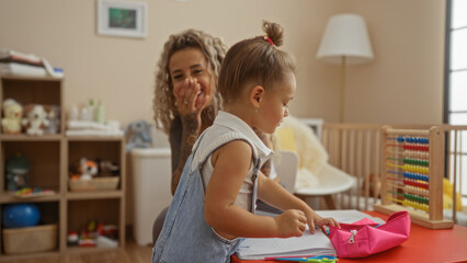 Mother and daughter playing together in a kindergarten room filled with toys, illustrating family love in a playful indoor setting with a woman and child sharing quality time.