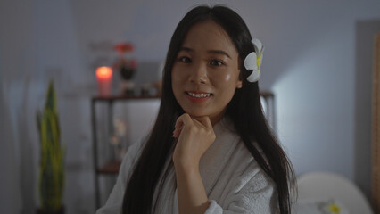 Young, beautiful, asian woman in a wellness spa center with ambient lighting, enjoying a relaxing...