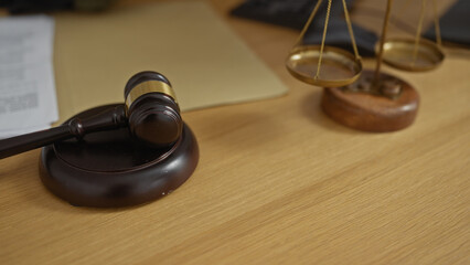 Gavel and scales of justice on a wooden desk in a lawyer's office symbolize legal proceedings,...