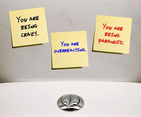 Notes stick on wall with gaslighting phrases - you're being crazy - You're being paranoid - You're...