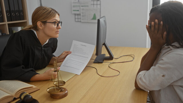 Judge woman in courtroom talking to a distressed client with documents on the table