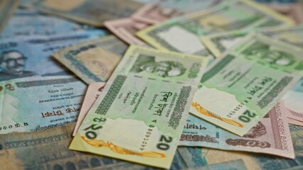 Bangladesh currency banknotes in various denominations featuring taka scattered closely together,...