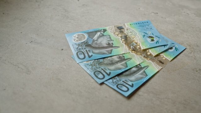 Australian ten-dollar banknotes scattered on a concrete surface, highlighting modern currency design from australia.